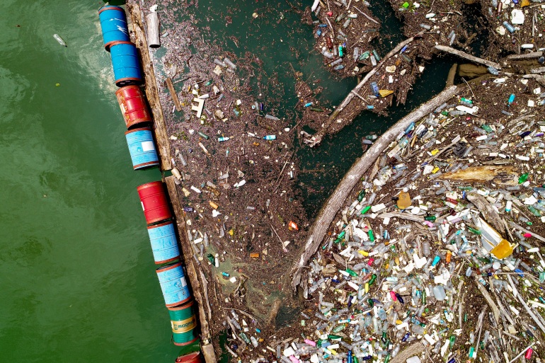 Plastic bottles, wooden planks, rusty barrels and other garbage clog the Drina river near the eastern Bosnian town of Visegrad, Bosnia, Thursday, May 25, 2023. (AP Photo/Eldar Emric)